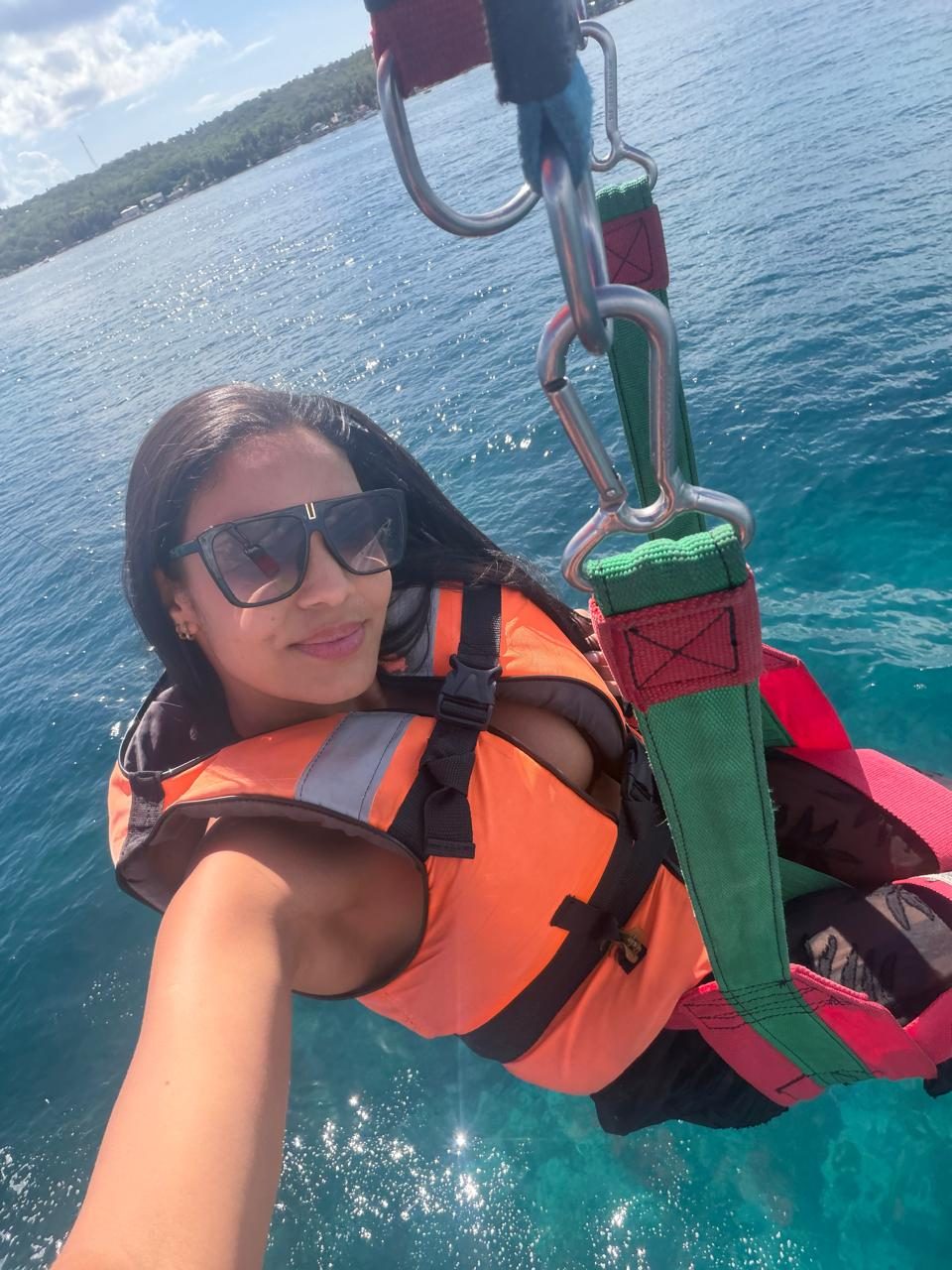 Cliente de colete no parasail sobre o mar